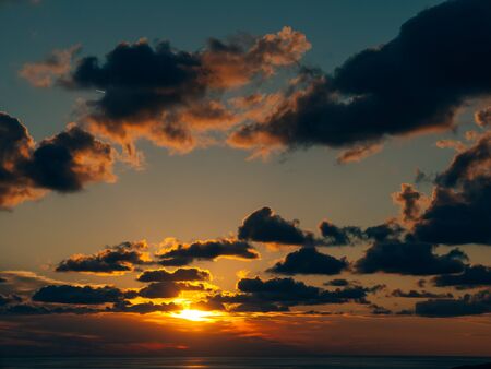 Sunset in the sky. Sunset sky in the clouds and the red sun.