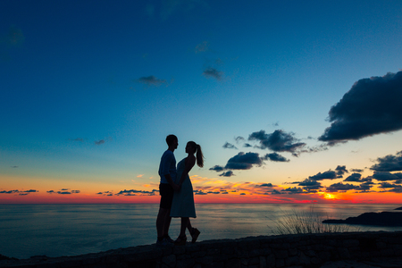 Silhouette of a newlywed couple at the sea at sunset. Wedding in Montenegro. Silhouettes of the couple, the bride and groom.の写真素材