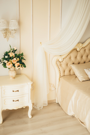 Bedside table in the bedroom next to the bed.の写真素材