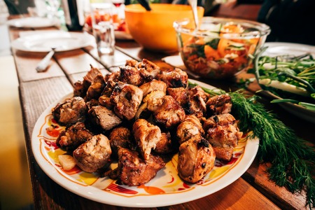Shish kebab on skewers in a plate on a wooden table.の写真素材