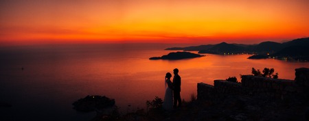 Silhouettes of couples near Sveti Stefan island in Montenegro
