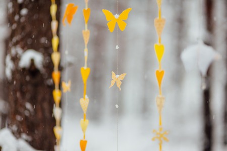 garland of paper butterflies. Against the background of a snow-covered forest.の写真素材