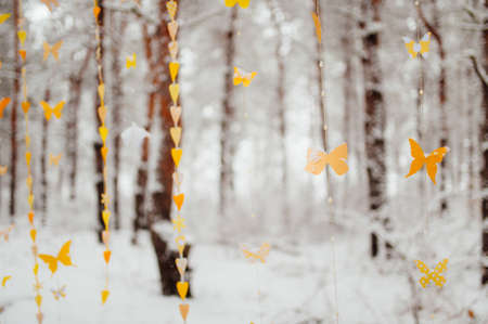 garland of paper butterflies. Against the background of a snow-covered forest.の写真素材