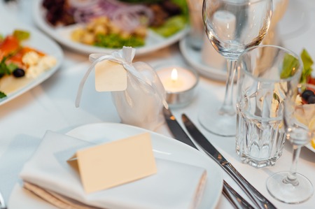Table setting at a wedding banquet. Decoration flowers. A close-up of a plate with cutlery.