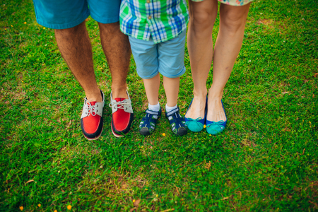 Childrens legs and feet of parents. The family walks along the beach in Montenegro.の写真素材