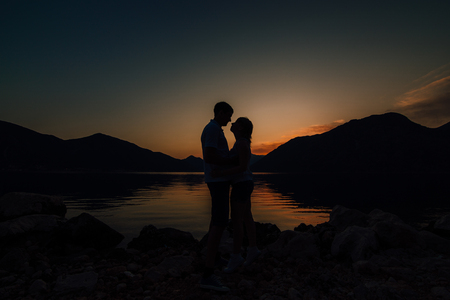 Silhouette of a newlywed couple on the background of the setting sun on the sea in Montenegro.の写真素材