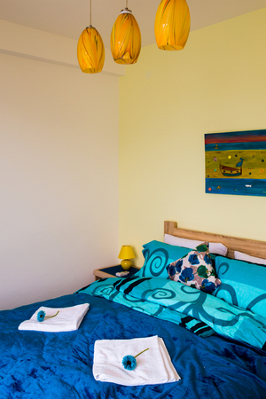 Interior of the bedroom in white and green colors. The large double bed is blue.の写真素材