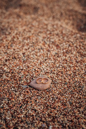 Wedding rings of newlyweds on beach pebbles. Engagement gold rings. Wedding in Montenegro.の写真素材