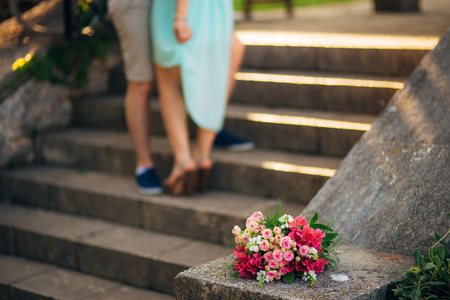 colorful autumn bouquet and two women legs with leather boots, closeupの写真素材