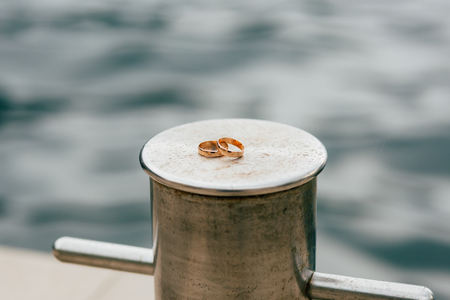 Wedding rings of the newlyweds near the sea. Engagement gold rings. Wedding in Montenegro.の写真素材