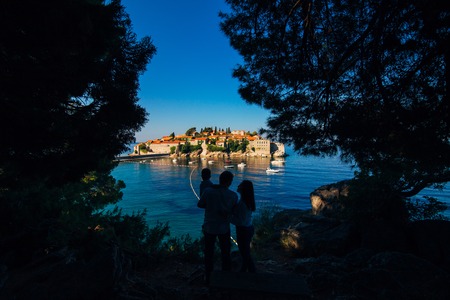 Silhouette of a family with children against the backdrop of the setting sun and sea in Montenegro.の写真素材