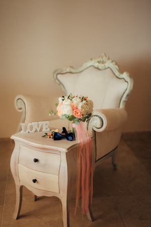 Bow tie and boutonniere on a wooden tableの写真素材