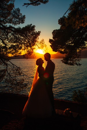 Silhouettes at sunset on the beach in Montenegroの写真素材