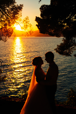Silhouettes at sunset on the beach in Montenegroの写真素材