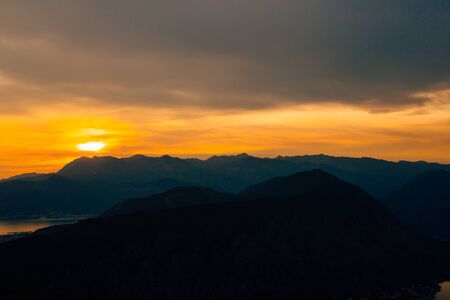 Sunset in Montenegro over the mountains and the sea. Orange sunsets.