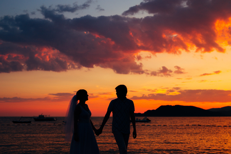 Silhouettes at sunset on the beach in Montenegroの写真素材
