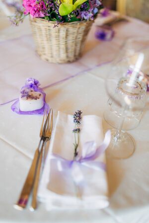 Wedding table setting at a banquet. A plate and instruments tied with a purple ribbon.の写真素材