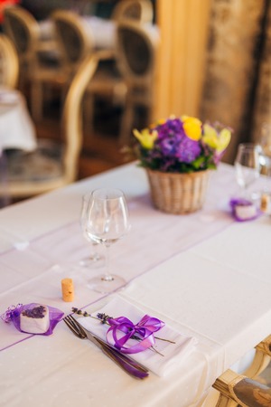 Wedding table setting at a banquet. A plate and instruments tied with a purple ribbon.の写真素材