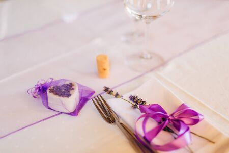 Wedding table setting at a banquet. A plate and instruments tied with a purple ribbon.の写真素材