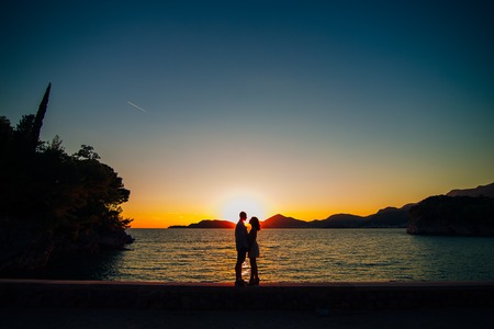 Silhouettes at sunset on the beach in Montenegroの写真素材