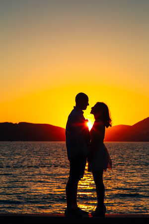 Silhouettes at sunset on the beach in Montenegroの写真素材