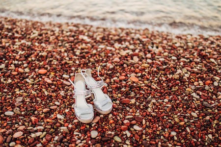 Wedding shoes of the bride on the seashore, on the sea pebble. Weddings in Montenegro.の写真素材