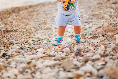 Childrens legs and feet of parents. The family walks along the beach in Montenegro.の写真素材