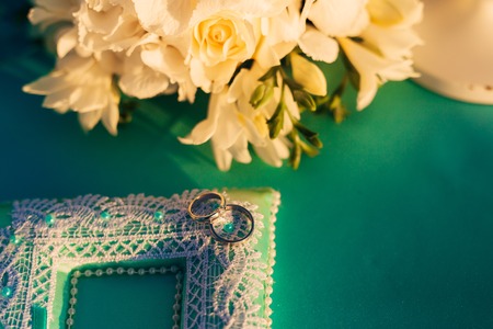 Wedding rings of a newly-married couple on a cushion for rings. Engagement gold rings. Wedding in Montenegro.の写真素材