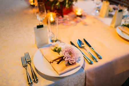 Table setting at a wedding banquet. Decoration flowers. A close-up of a plate with cutlery.の写真素材