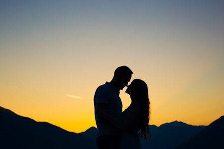 Silhouette of a newlywed couple on the background of the setting sun on the sea in Montenegro.の写真素材