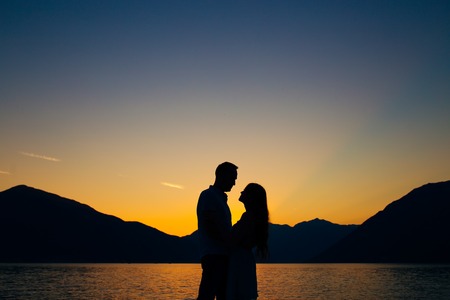Silhouette of a newlywed couple on the background of the setting sun on the sea in Montenegro.の写真素材