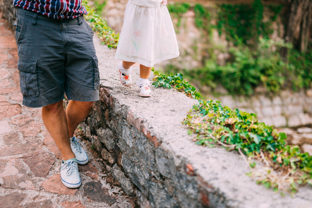 Childrens legs and feet of parents. The family walks along the beach in Montenegro.の写真素材