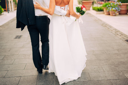 Happy beautiful bride outdoors. Wedding dress fluttering in the wind. Building in the background.の写真素材