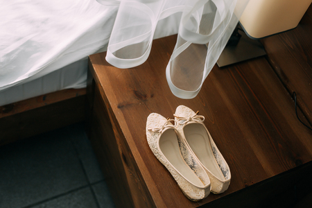 Cream shoes of the bride on green on a wooden table table. Wedding in Montenegro.の写真素材