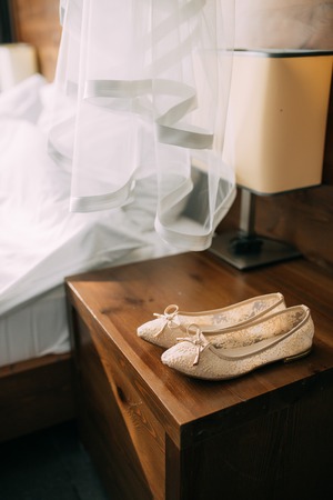 Cream shoes of the bride on green on a wooden table table. Wedding in Montenegro.の写真素材