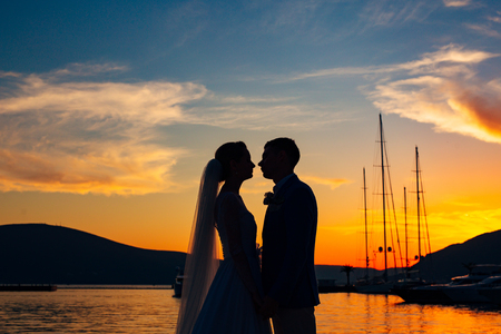Silhouette of a newlywed couple on the background of the setting sun on the sea in Montenegro.の写真素材