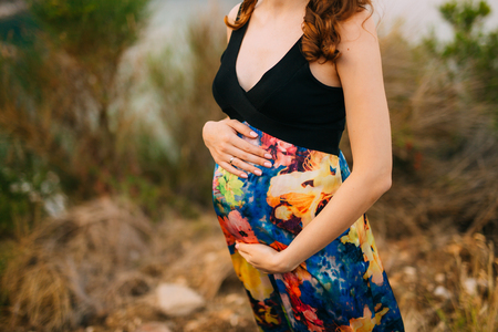Pregnant woman holding belly with hands in Montenegroの写真素材
