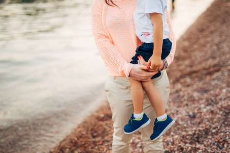 Mom holding the baby. On the beach in Montenegro.の写真素材