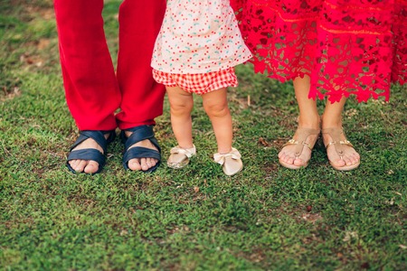 Children's legs and feet of parents. The family walks along the beach in Montenegro.の写真素材