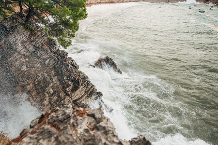 Rocks sticking out of the water and the waves washed in Montenegro.の写真素材