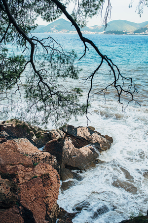 Rocks sticking out of the water and the waves washed in Montenegro.の写真素材
