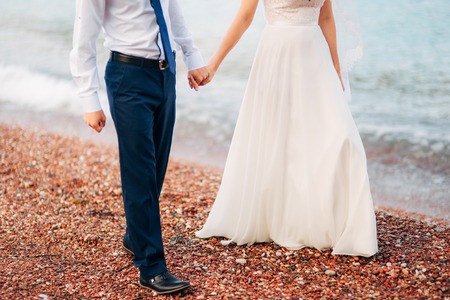 Women's and men's feet in the sand. Wedding in Montenegroの写真素材