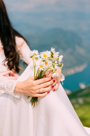 Wedding bouquet of daisies in the hands of the bride. Wedding in Montenegro.の写真素材