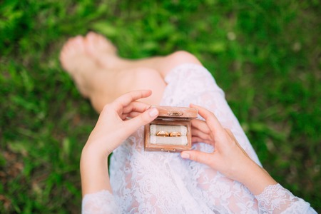 Wedding rings in a wooden box for rings in the hands of the bride. Wedding jewelry.の写真素材