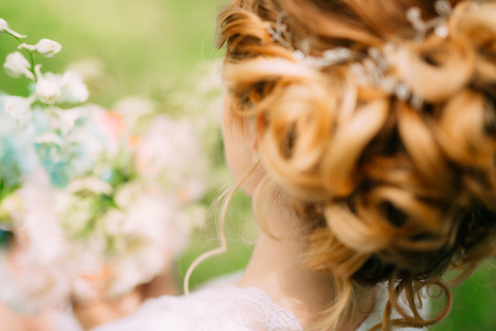 Hairstyle of the bride close-up. The hairdresser finished making a hairstyle.の写真素材