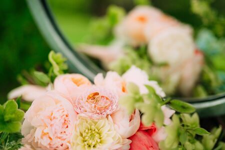 Wedding rings on a bouquet of peonies. Wedding jewelry.の写真素材