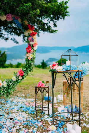 Round wedding arch of flowers and olive branches. Hanging on the tree, near the fort of Gorazda in Montenegro. Overlooking the Bay of Kotor at sunsetの写真素材