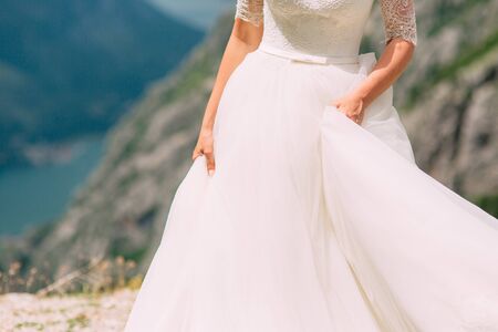 Touches the dress. The bride waving her dress. Fluttering dress of the bride. Wedding in Montenegro.の写真素材