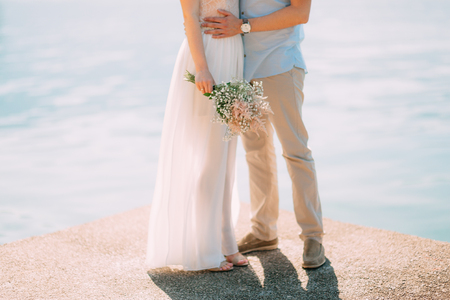 The groom embraces the bride on the beach. Wedding in Montenegro and Croatia.の写真素材