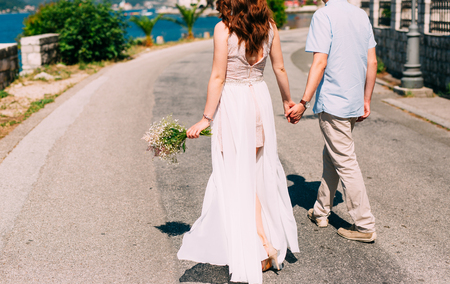 Newlyweds hold hands on the sea. Couple holding hands. Wedding in Montenegro.の写真素材